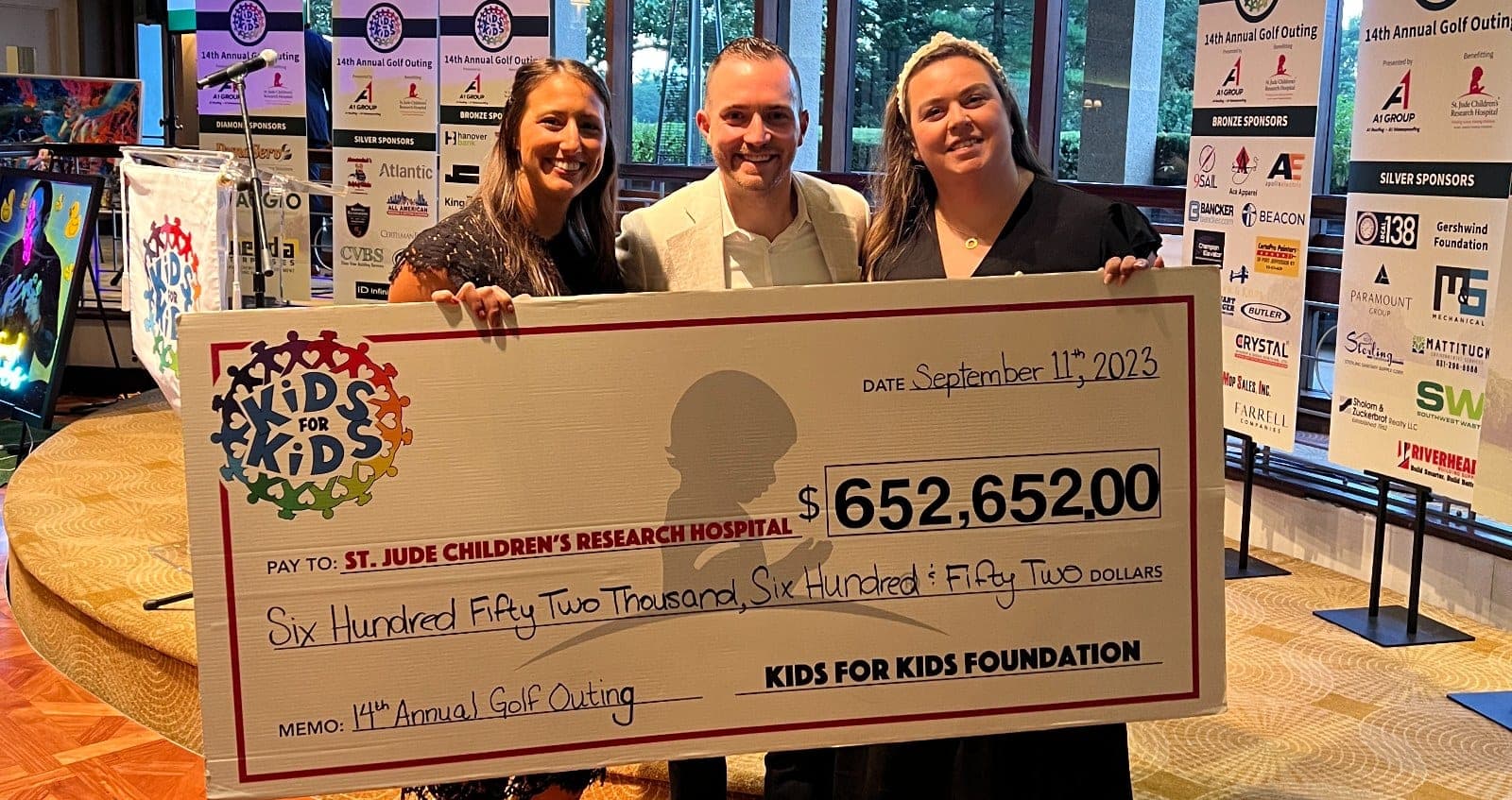 Chris Dare with two colleagues presenting a $652,652 check to St. Jude Children's Research Hospital at the 14th Annual Kids for Kids Golf Outing