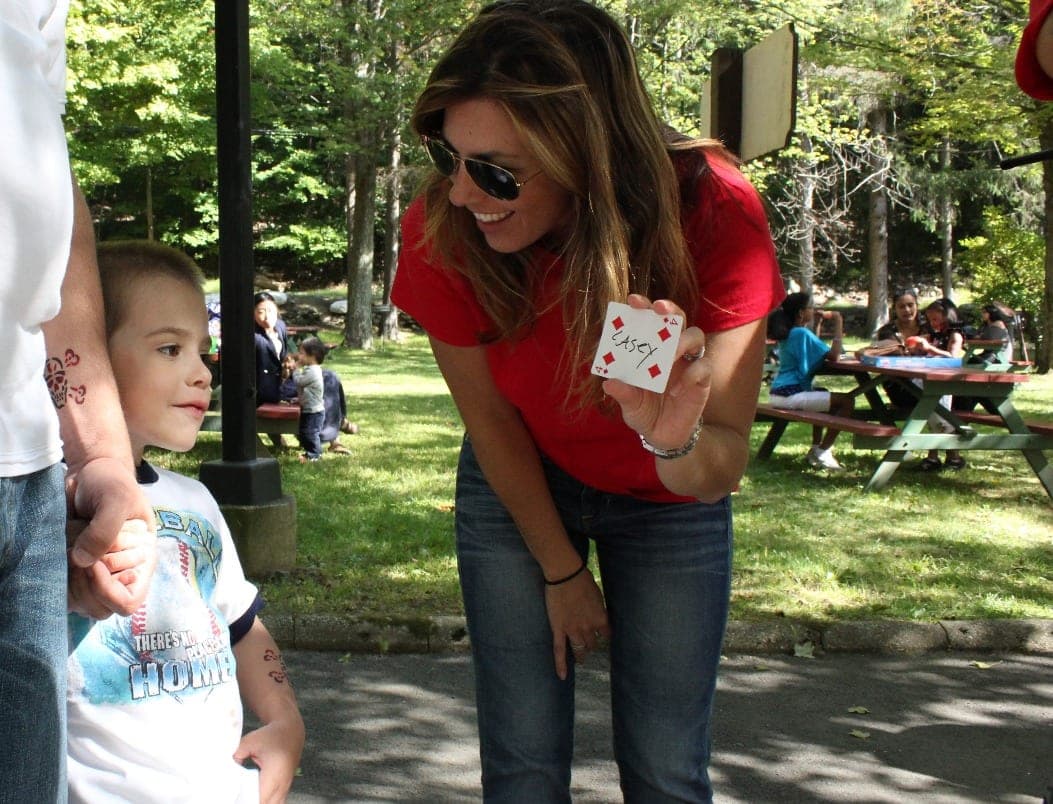 Chris Dare with a guest holding a fan of cards at a charity gala