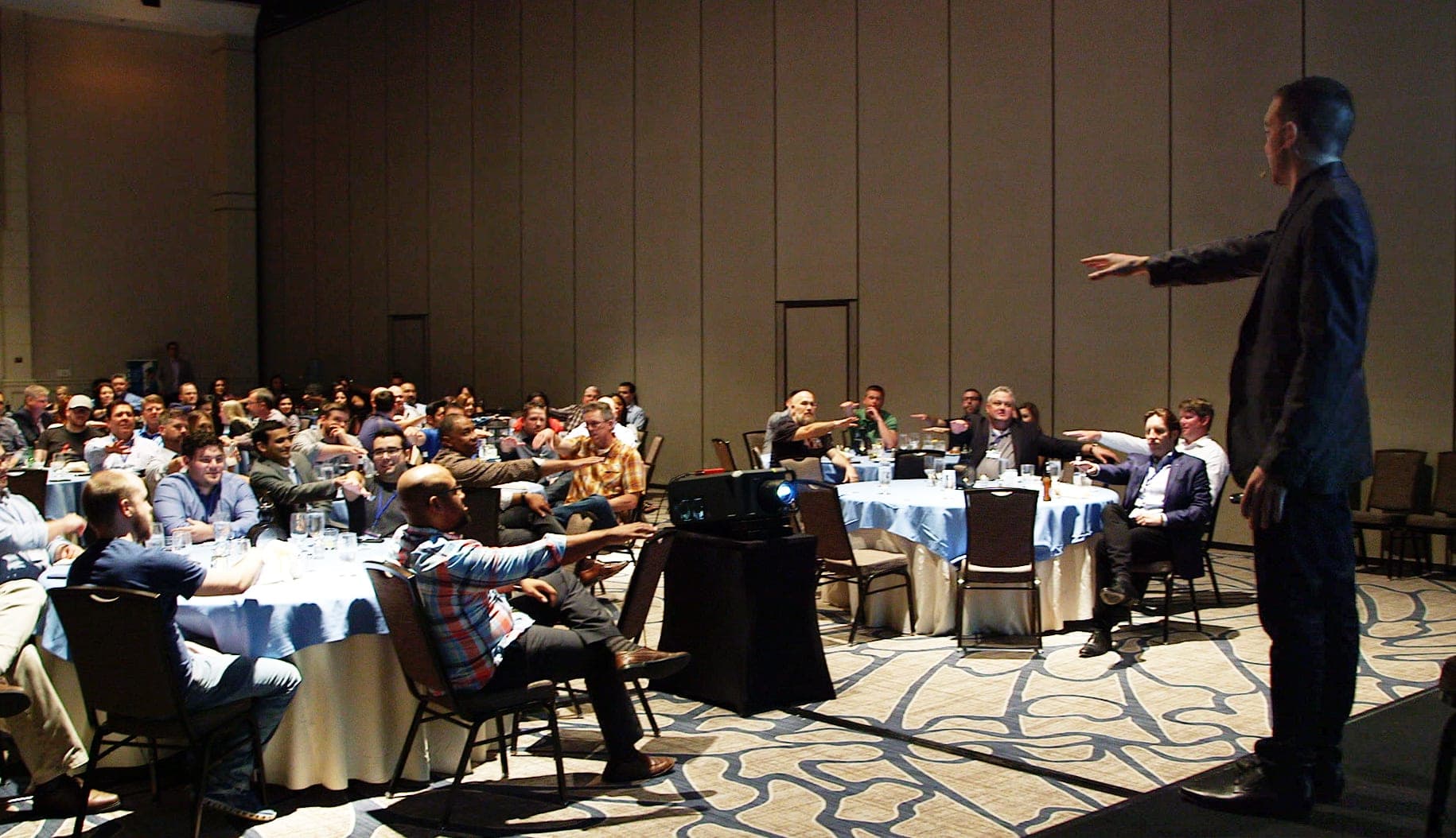 Chris Dare leading an audience through an interactive moment during a corporate motivational talk