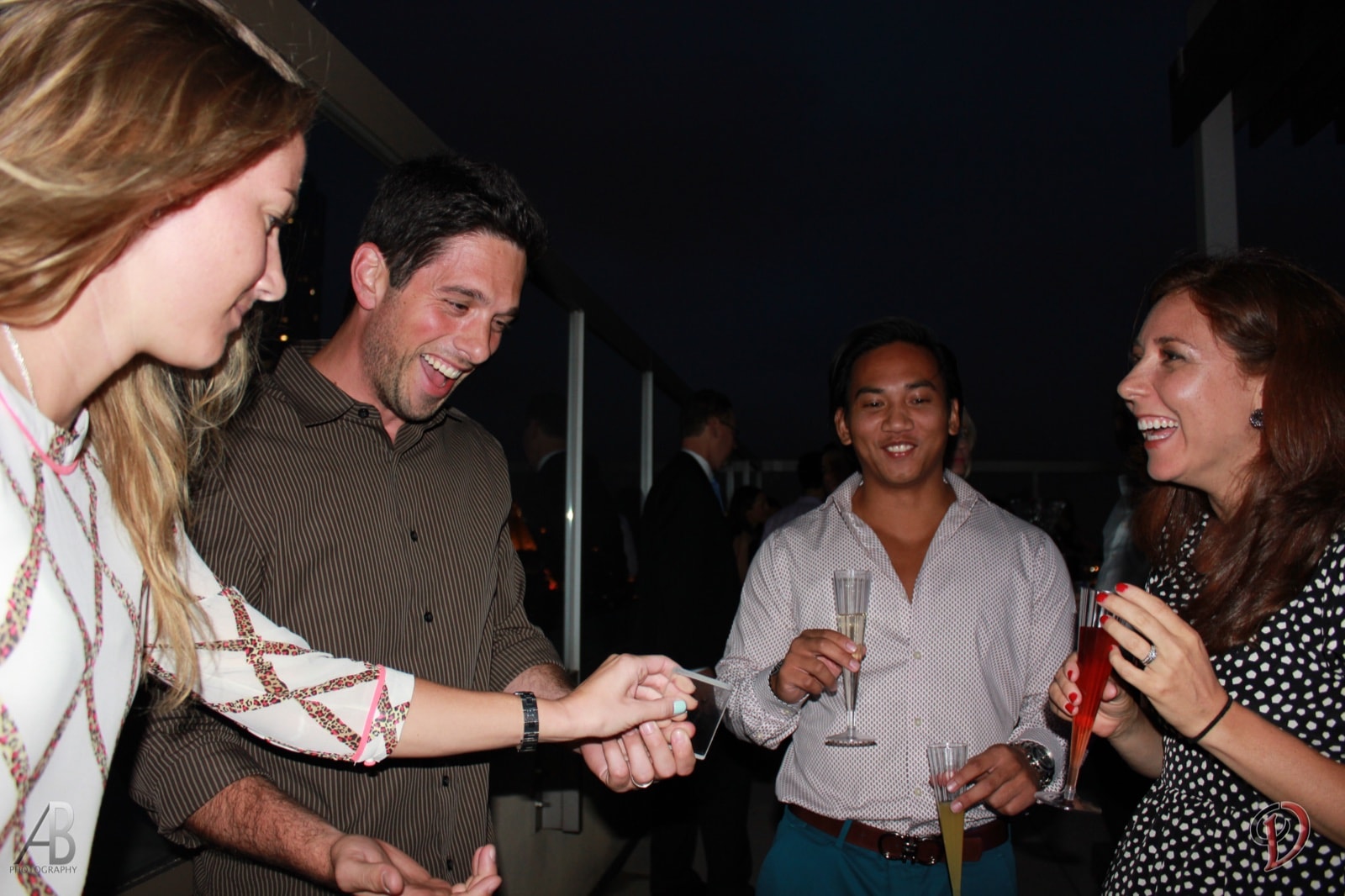 Chris Dare performing a sleight-of-hand trick for guests at an outdoor evening event