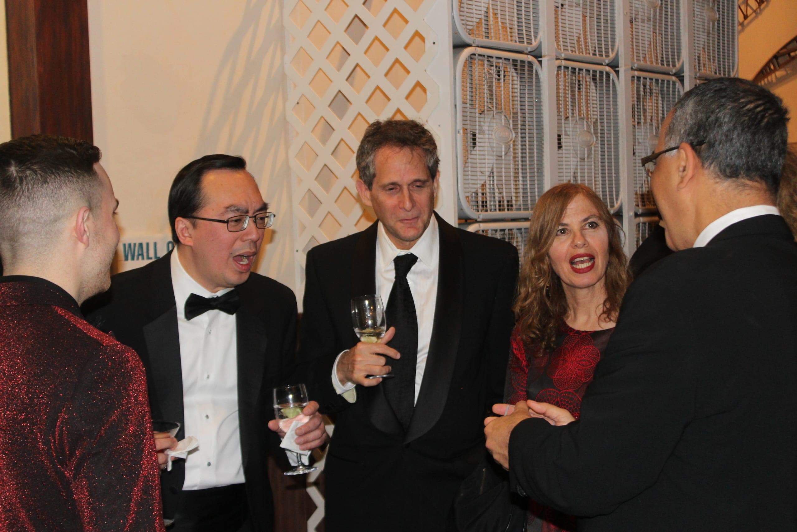 Guests laughing in astonishment during Chris Dare's close-up magic at a charity gala